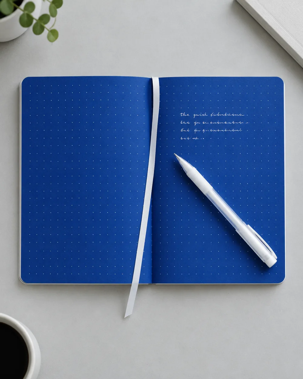Cahier Noctes ouvert, pages bleues pointillées, écriture blanche